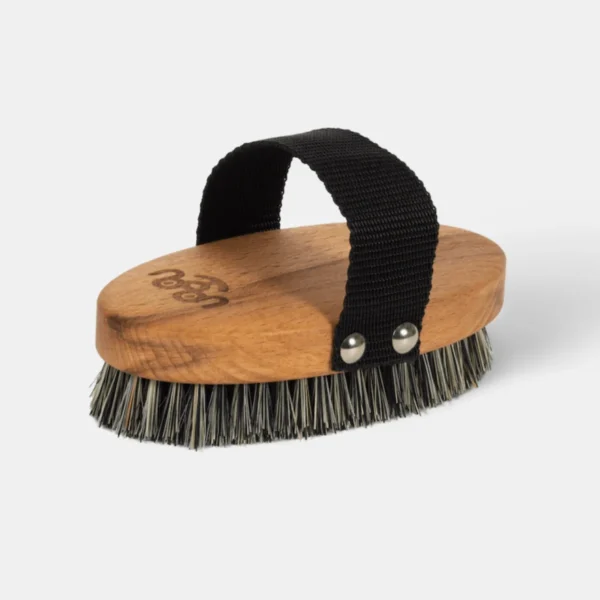 Brosse pour chien avec poignée en sangle noire, conçue en bois naturel et dotée de poils rigides pour entretenir les pelages courts. Idéale pour éliminer les poils morts et stimuler la peau.